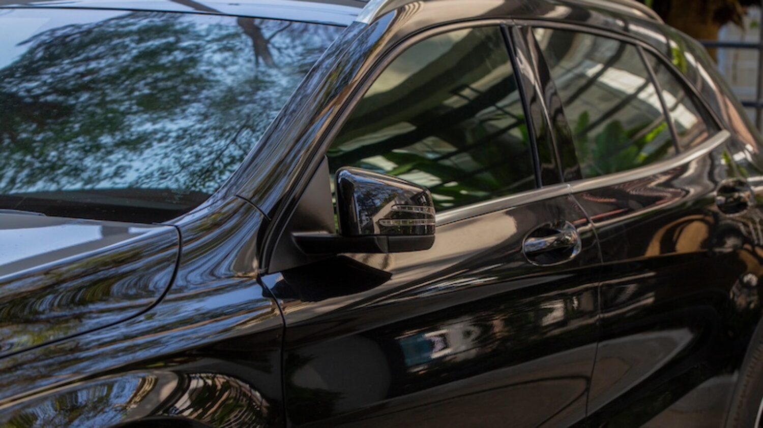Rear-view mirror or door mirror closed for safety at car park, Side mirror of gray car , black tinted glass